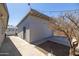 View of backyard detached garage with adjacent patio space and bare-branched tree at 2346 E Sylvia St, Phoenix, AZ 85022