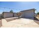 Enclosed backyard with concrete patio, detached garage, desert landscaping and festive string lights overhead at 2346 E Sylvia St, Phoenix, AZ 85022