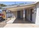 View of carport showing concrete flooring, neutral stucco and access doors to residence at 2346 E Sylvia St, Phoenix, AZ 85022