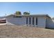 Side view of a single-story house with a gravel yard, gray stucco exterior, and unique vertical window accents at 2346 E Sylvia St, Phoenix, AZ 85022