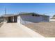 Exterior view of a gray stucco house featuring a covered parking area and low-maintenance gravel yard at 2346 E Sylvia St, Phoenix, AZ 85022