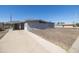 Exterior view of a gray stucco house featuring a covered parking area and low-maintenance gravel yard at 2346 E Sylvia St, Phoenix, AZ 85022