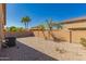 Desert backyard with block wall, desert landscaping, and palm trees in the background at 44188 W Cydnee Dr, Maricopa, AZ 85138