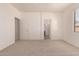 Bright bedroom with neutral carpet, standard ceiling fan, and ensuite bathroom at 44188 W Cydnee Dr, Maricopa, AZ 85138