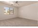 Spacious carpeted bedroom with a ceiling fan and large window offering natural light at 44188 W Cydnee Dr, Maricopa, AZ 85138