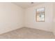 Bright bedroom with neutral carpet, white walls, and a window providing natural light at 44188 W Cydnee Dr, Maricopa, AZ 85138