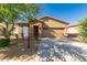 A tan single-story home with a red-tiled roof, a two-car garage, and a spacious driveway at 44188 W Cydnee Dr, Maricopa, AZ 85138