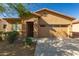 Home exterior featuring tan stucco, a front entry door, a two-car garage, and desert landscaping at 44188 W Cydnee Dr, Maricopa, AZ 85138