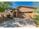 A one-story tan home with a red-tiled roof, a two-car garage, and mature landscaping at 44188 W Cydnee Dr, Maricopa, AZ 85138