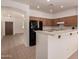 Kitchen with breakfast bar, tile floors, and black refrigerator at 44188 W Cydnee Dr, Maricopa, AZ 85138