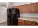 View of kitchen cabinetry and black refrigerator with ice and water dispenser at 44188 W Cydnee Dr, Maricopa, AZ 85138
