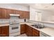 Traditional kitchen featuring wood cabinets, laminate countertops and a white range at 44188 W Cydnee Dr, Maricopa, AZ 85138
