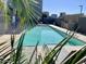A tranquil community pool with lounge chairs, clear blue water, and palm trees at 535 W Thomas Rd # 407, Phoenix, AZ 85013