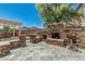 Impressive outdoor kitchen and seating area with stone details and a tiled patio at 10945 E Storia Ave, Mesa, AZ 85212