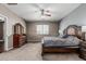 Primary bedroom boasts carpet floors, a ceiling fan, and lots of windows to enjoy the view at 10945 E Storia Ave, Mesa, AZ 85212