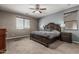 Primary bedroom boasts carpet floors, a ceiling fan, and lots of windows to enjoy the view at 10945 E Storia Ave, Mesa, AZ 85212