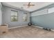 Carpeted bedroom with a ceiling fan, two windows, and neutral-painted walls at 10945 E Storia Ave, Mesa, AZ 85212