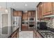 Spacious kitchen with stainless appliances, dark wood cabinets and a large island with seating at 10945 E Storia Ave, Mesa, AZ 85212