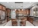 Gourmet kitchen featuring dark wood cabinetry, a large island, and stainless steel appliances at 10945 E Storia Ave, Mesa, AZ 85212