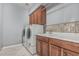 Functional laundry room with updated cabinets, ample counter space, and modern washer/dryer at 10945 E Storia Ave, Mesa, AZ 85212
