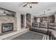 Open living space featuring a stone fireplace, hardwood floors, and a view of the modern kitchen at 10945 E Storia Ave, Mesa, AZ 85212