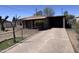 Exterior front view of a single-story home with a covered carport and cracked concrete driveway at 112 S 28Th Dr, Phoenix, AZ 85009
