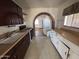 Kitchen with contrasting cabinets, sink, stove, and an arched entrance at 112 S 28Th Dr, Phoenix, AZ 85009