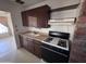 Kitchen view with dark cabinets, stove, and an open layout at 112 S 28Th Dr, Phoenix, AZ 85009