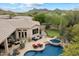 Beautiful aerial view of backyard featuring a pool, spa, putting green, and stunning mountain views at 11448 E Blue Sky Dr, Scottsdale, AZ 85262