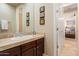 Bathroom featuring a vanity with dark wood cabinets, tile countertops, and a framed mirror at 11448 E Blue Sky Dr, Scottsdale, AZ 85262