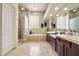 Bright bathroom with a soaking tub, glass block window, and a separate walk-in shower at 11448 E Blue Sky Dr, Scottsdale, AZ 85262