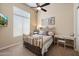 Cozy bedroom with a gold metal frame bed, a ceiling fan, and a bright window with blinds at 11448 E Blue Sky Dr, Scottsdale, AZ 85262