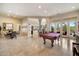Expansive game room with a pool table, tile flooring, and access to the outdoor area at 11448 E Blue Sky Dr, Scottsdale, AZ 85262