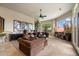 Inviting living room features plush seating, a ceiling fan, and large windows offering views of the desert landscape at 11448 E Blue Sky Dr, Scottsdale, AZ 85262