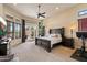 Relaxing main bedroom featuring a large bed, ceiling fan, and access to a private outdoor patio at 11448 E Blue Sky Dr, Scottsdale, AZ 85262