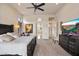 Comfortable bedroom with a large bed, ceiling fan, and a view of the attached bathroom at 11448 E Blue Sky Dr, Scottsdale, AZ 85262
