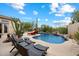 Resort-style pool area features chaise lounges, desert plants, and a waterfall for relaxation at 11448 E Blue Sky Dr, Scottsdale, AZ 85262