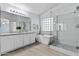 Modern bathroom features a soaking tub, glass-enclosed shower, and dual vanity sinks at 119 S Monterey St, Gilbert, AZ 85233