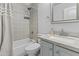 Bathroom featuring decorative floor-to-ceiling tiles, modern vanity, and shower-tub combo at 119 S Monterey St, Gilbert, AZ 85233