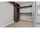 Walk-in closet boasts custom wood shelving and ample storage space and laminate floors at 119 S Monterey St, Gilbert, AZ 85233