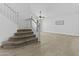 View of a foyer with a staircase, carpeted stairs, wood railing, and open living space at 119 S Monterey St, Gilbert, AZ 85233