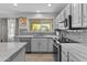 Modern kitchen featuring stainless steel appliances, light gray cabinets, and a view to the backyard at 119 S Monterey St, Gilbert, AZ 85233