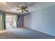 Spacious bedroom featuring a ceiling fan and sliding glass doors to a patio at 13261 N 110Th Ave, Sun City, AZ 85351