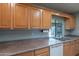 Functional kitchen featuring wood cabinetry, and stainless steel sink beneath a window at 13261 N 110Th Ave, Sun City, AZ 85351