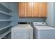 Functional laundry room featuring a side-by-side washer and dryer and ample shelving for storage at 13261 N 110Th Ave, Sun City, AZ 85351