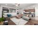 Open-concept living room showcasing the kitchen, wood floors, modern furniture, neutral colors and ceiling fans at 14921 W Luna S Dr, Litchfield Park, AZ 85340