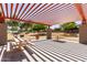 Covered outdoor picnic area with tables, ideal for gatherings in a well-maintained community park with an orange pergola at 14921 W Luna S Dr, Litchfield Park, AZ 85340