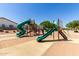 Fun playground with slides and climbing structures in a Gathering-friendly community park with a green and red theme at 14921 W Luna S Dr, Litchfield Park, AZ 85340