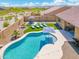 Aerial view of a backyard oasis with a sparkling pool, manicured lawn, lounge seating, and privacy fencing at 15663 S 183Rd Dr, Goodyear, AZ 85338