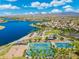 Aerial view of the lake community showcasing a lake, pool, tennis courts, and playground at 15663 S 183Rd Dr, Goodyear, AZ 85338